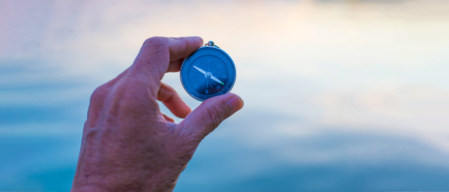 Photo of hand holding compass - concept: why you need independent fiduciary guidance